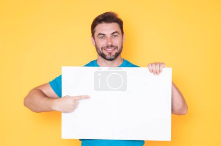 Photo for Information concept. Man with blank placard. Demonstrating copy space for your text or design. Man showing empty advertisement board on studio background. Blank placard, signboard for ad - Royalty Free Image