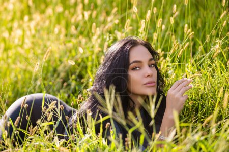Photo for Sexy woman lying on grass. Summer beauty sexy woman outdoor portrait. Beautiful woman relaxing in the field with green grass - Royalty Free Image