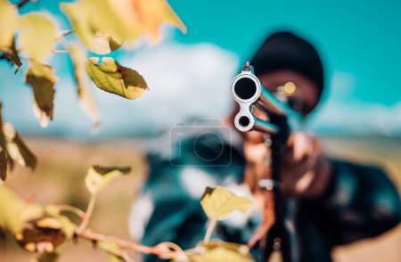 Photo for Hunting Licenses. Hunter with shotgun gun on hunt. Autumn hunting season. Poacher with Rifle Spotting Some Deers. Track down - Royalty Free Image