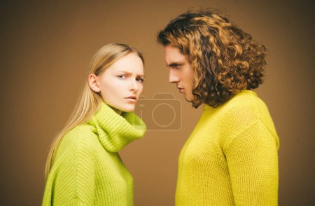 Foto de Fashion girl and guy in outlet yellow clothes posing in studio. Fashion couple each other - Imagen libre de derechos