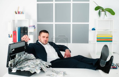 Photo for Richness concept. Successful entrepreneur wasting money. Businessman with cash money in office. Banknotes, dollars. Businessman got cash money. Man with many dollar banknotes in suitcase - Royalty Free Image