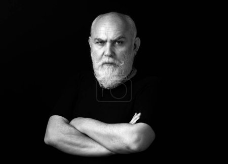Téléchargez les photos : Sérieux senior. Portrait d'un homme mature sur fond noir - en image libre de droit