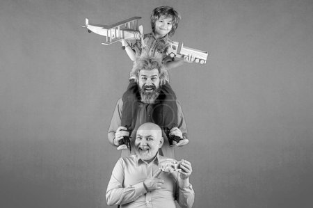 Foto de Generación de hombres: el abuelo, el padre y el nieto se abrazan mirando a la cámara y sonriendo. Concepto del día de los padres. Concepto del día de los padres. Hombres en diferentes edades fondo aislado - Imagen libre de derechos