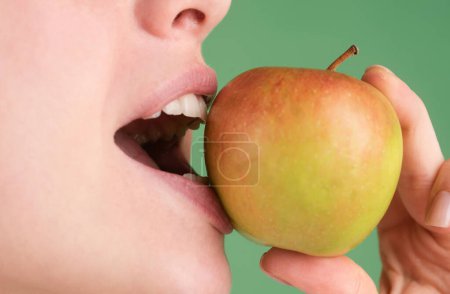 Foto de Cuidado dental. Primeros dientes blancos sanos con una manzana - Imagen libre de derechos