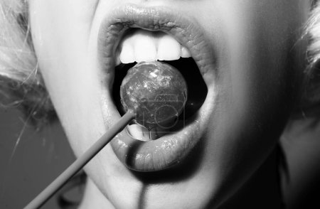 Photo for Sexual lips with candy, sexy sweet dreams. Female mouth licks chupa chups, sucks lollipop - Royalty Free Image