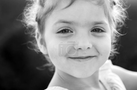 Téléchargez les photos : Petite fille printanière. Portrait d'enfant ensoleillé. Enfant souriant, émotions positives. Journées estivales - en image libre de droit