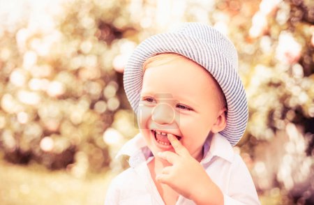 Photo for Child on the green grass in summer park. Baby face closeup. Funny launching kid boy close up portrait. Blonde kid, smiling emotion face - Royalty Free Image