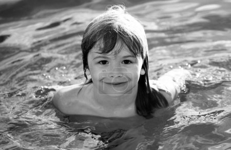 Téléchargez les photos : Portrait de petit garçon nageant dans la mer. Enfant riant dans l'eau des vagues en mer. Visage drôle d'enfants - en image libre de droit
