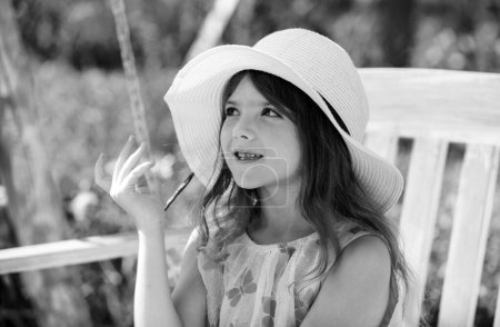 Photo for Caucasian little girl wearingstraw hat standing outdoors. Funny kids face - Royalty Free Image