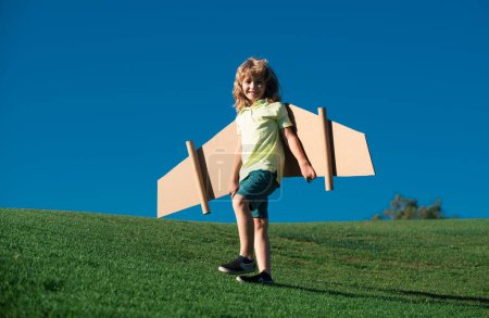 Photo for Child boy playing pilot on the sky blue background. Kid dreaming. Child playing with toy jetpack. Kid pilot having fun at park. Portrait of child against summer sky. Travel and freedom concept - Royalty Free Image