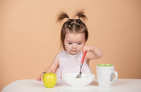 Baby eating kids food. Kid girl eating healthy food with spoon