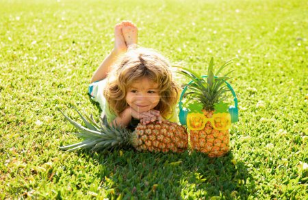 Photo for Pineapple kid boy and pineapples on summer vacation - Royalty Free Image