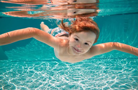 Foto de Divertido retrato facial de niño nadando y buceando bajo el agua con diversión en la piscina. Niño en el agua nadando bajo el agua y sonriendo. Los niños nadan bajo el agua. Cara divertida de los niños - Imagen libre de derechos
