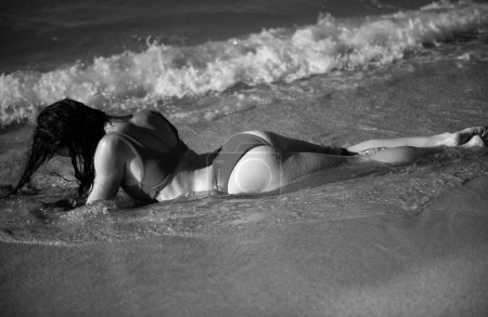 Foto de Mujer joven en un traje de baño sexy en la playa. Chica sensual en el mar - Imagen libre de derechos