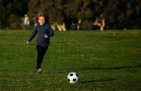 Cute boy kicking soccer ball. Sports kid during soccer training. Soccer boy, child play football