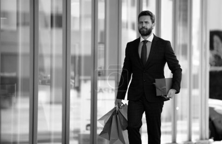 Foto de Hombre de negocios llevando bolsas de compras, caminando en la ciudad - Imagen libre de derechos