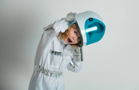 Téléchargez les photos : Portrait de petit astronaute émerveillé en casque et combinaison spatiale de protection. Petit garçon astronaute drôle - en image libre de droit