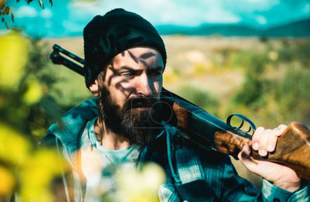 Un homme tenant un fusil. Chasseur avec fusil de chasse en chasse. Chasse en forêt printanière. Grand match. Repérage
