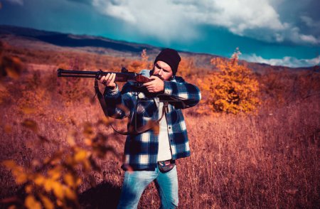 Photo for Autumn hunting season. Hunter with shotgun gun on hunt. Hunter with Powerful Rifle with Scope Spotting Animals - Royalty Free Image