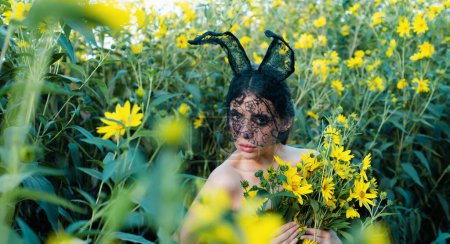 Foto de Hermosa joven sexy mujer con orejas de conejo. Flores amarillas y niña bonita - Imagen libre de derechos