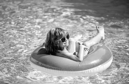 Foto de Vacaciones de verano. Fin de semana de verano. Un chico en la piscina. Niño en el parque acuático. Chico gracioso en círculo de goma inflable - Imagen libre de derechos
