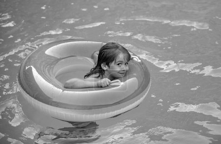 Foto de Vacaciones de verano. Fin de semana de verano para niños. Niño en piscina de natación con círculo de goma inflable - Imagen libre de derechos