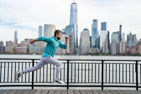 Téléchargez les photos : Cours ! Un homme en bonne santé qui court à New York. Sport de fitness, homme coureur fait du jogging près de Manhattan. Un homme courant dans la rue américaine. Un homme en tenue de sport à New York. Vêtements de sport pour coureurs matures - en image libre de droit