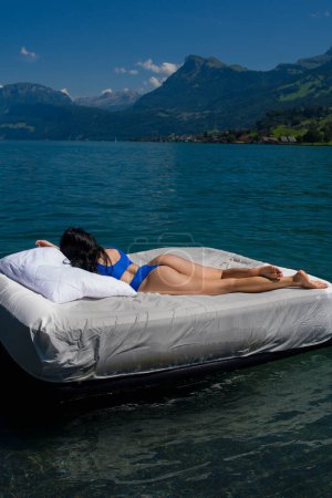 Foto de Fitness sexy modelo femenino Relajante en Spa Resort. Mujer sexy durmiendo o descansando en un colchón en el agua. Concepto de colchón de agua. Descanso verano - Imagen libre de derechos