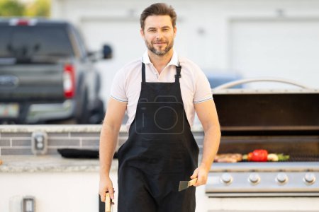 Photo for Cook man preparing barbecue grill outdoor. Man cooking tasty food on barbecue grill at backyard. Chef preparing food on barbecue. Millennial man grilling meat on grill. Bbq party. Meal grilling - Royalty Free Image