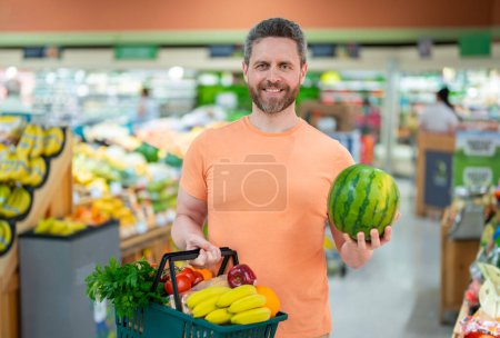 Photo for Man with grocery basket shopping at supermarket. Grocery store, shopping basket. Banner with man for grocery food store or supermarket. Man choosing food in store or grocery store - Royalty Free Image