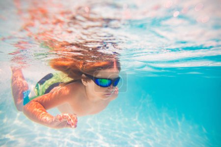 Photo for Kid swimming underwater. Summer kids. Happy little boy in swimming pool on summer day. Funny kid swimming and diving in pool. Kid underwater with splashes. Summer children water sports activity - Royalty Free Image