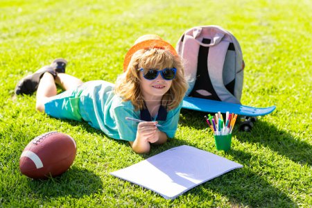 Photo for Child artist paints creativity vacation. Kid boy draws in park laying in grass - Royalty Free Image
