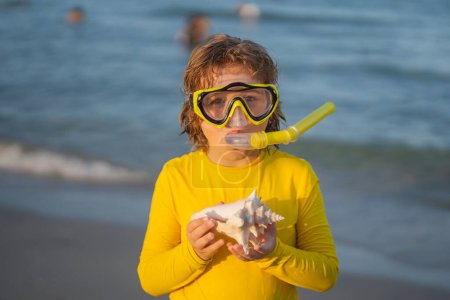 Foto de Snorkel de verano con niños. Vacaciones en playa. Un chico divertido usando una máscara de buceo de snorkel encontró un coral o concha en el agua del océano. Summer Kids Buceo de snorkel. El niño se sumerge en el agua. Vacaciones de verano - Imagen libre de derechos