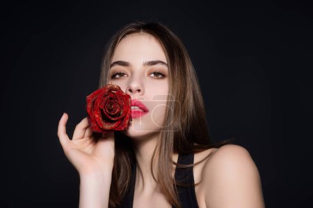 Foto de Beauty girl with red rose. Beautiful sensual woman hold flowers, studio portrait - Imagen libre de derechos