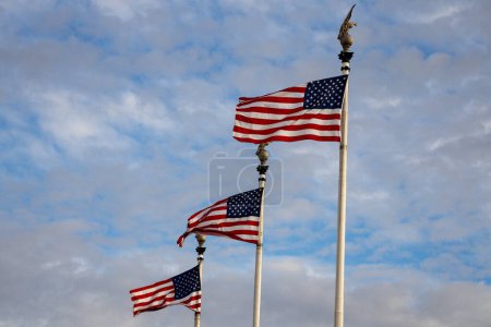 Téléchargez les photos : Drapeau américain sur ciel bleu USA. Drapeau agitant. Jour de l'indépendance. Le 4 juillet. Le concept du drapeau américain - en image libre de droit