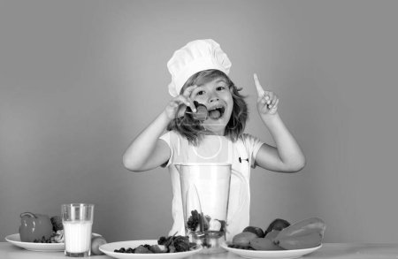 Photo for Portrait of chef child in cook hat hold spinach. Cooking at home, kid boy preparing food from vegetable and fruits. Healthy eating - Royalty Free Image