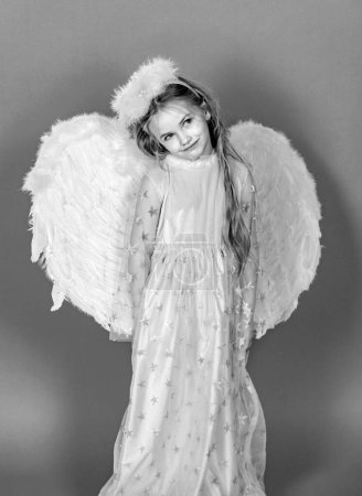 Téléchargez les photos : Angel child girl with wings, valentines day. Child with angelic character. Toddler girl wearing angel costume white dress and feather wings. Consept of innocent child - en image libre de droit