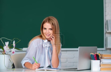 Photo for Female college student working on a laptop in classroom, preparing for an exam. Education, high school, university, learning and people concept - Royalty Free Image