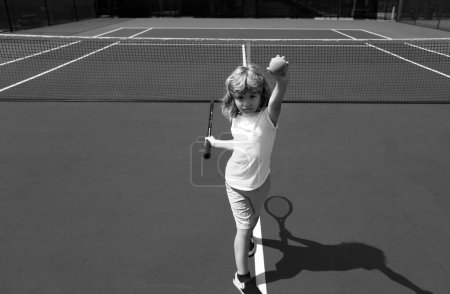 Foto de Un niño jugando al tenis. Niño golpeando de frente en el tenis - Imagen libre de derechos