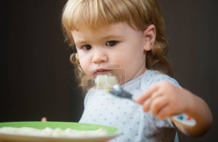 Photo for Cute little baby is being fed using spoon - Royalty Free Image