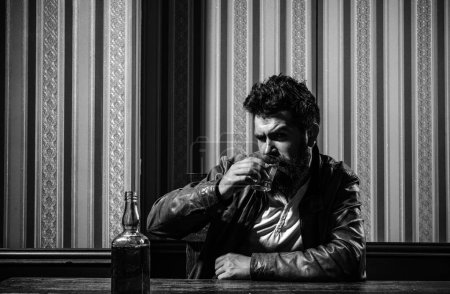 Photo for Upset man drinker alcoholic with glass drinking whiskey alone, sad depressed addicted. Bottle and glass of whisky. Man alcohol abuse - Royalty Free Image
