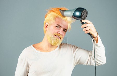 Téléchargez les photos : Homme barbu blonde avec sèche-cheveux. Soins capillaires mâle isolé - en image libre de droit