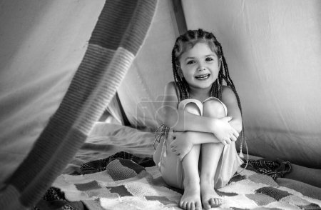 Foto de Chica jugando en la tienda. Camping infantil en el camping al aire libre. Divertirse fuera - Imagen libre de derechos