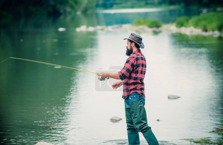 Photo for Young bearded man fishing at a lake or river. Flyfishing - Royalty Free Image