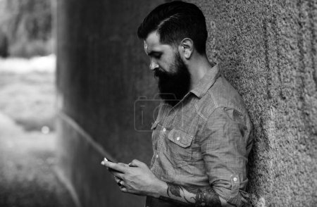 Photo for Young business man with smartphone on street. Talking on mobile phone. Smiling man with phone in the city. Businessman male - Royalty Free Image