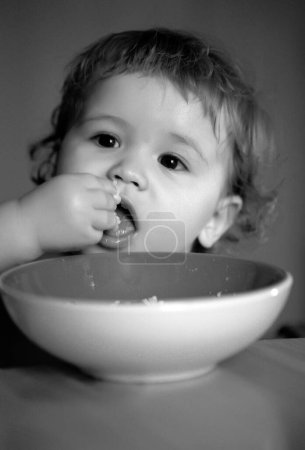 Téléchargez les photos : Portrait de drôle de petit garçon mangeant de la plaque gros plan - en image libre de droit
