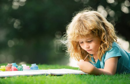 Téléchargez les photos : Enfants peinture dessin art. Un enfant dessine dans un parc d'été, peint de l'art. Petit artiste peintre dessiner des images en plein air - en image libre de droit