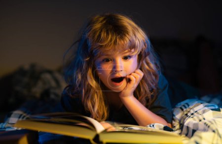 Téléchargez les photos : Enfant lisant un livre. Enfant au lit, garçon lisant un livre au lit. Contes au coucher conte de fées avant de se coucher - en image libre de droit