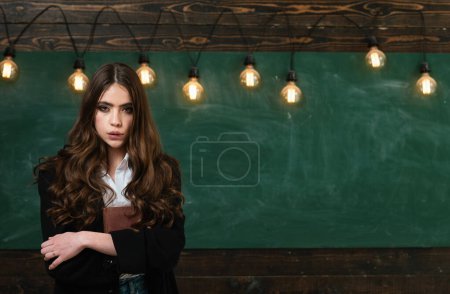Photo for Young teenager with school books. Cute schoolgirl posing solving problem on blackboard. Ready for school - Royalty Free Image