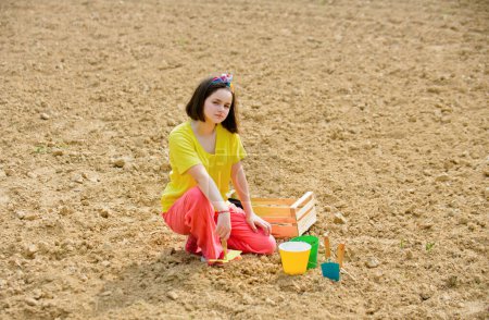 Photo for Child girl having fun with little shovel and plant in pot. Planting seedlings. Garden tools - Royalty Free Image